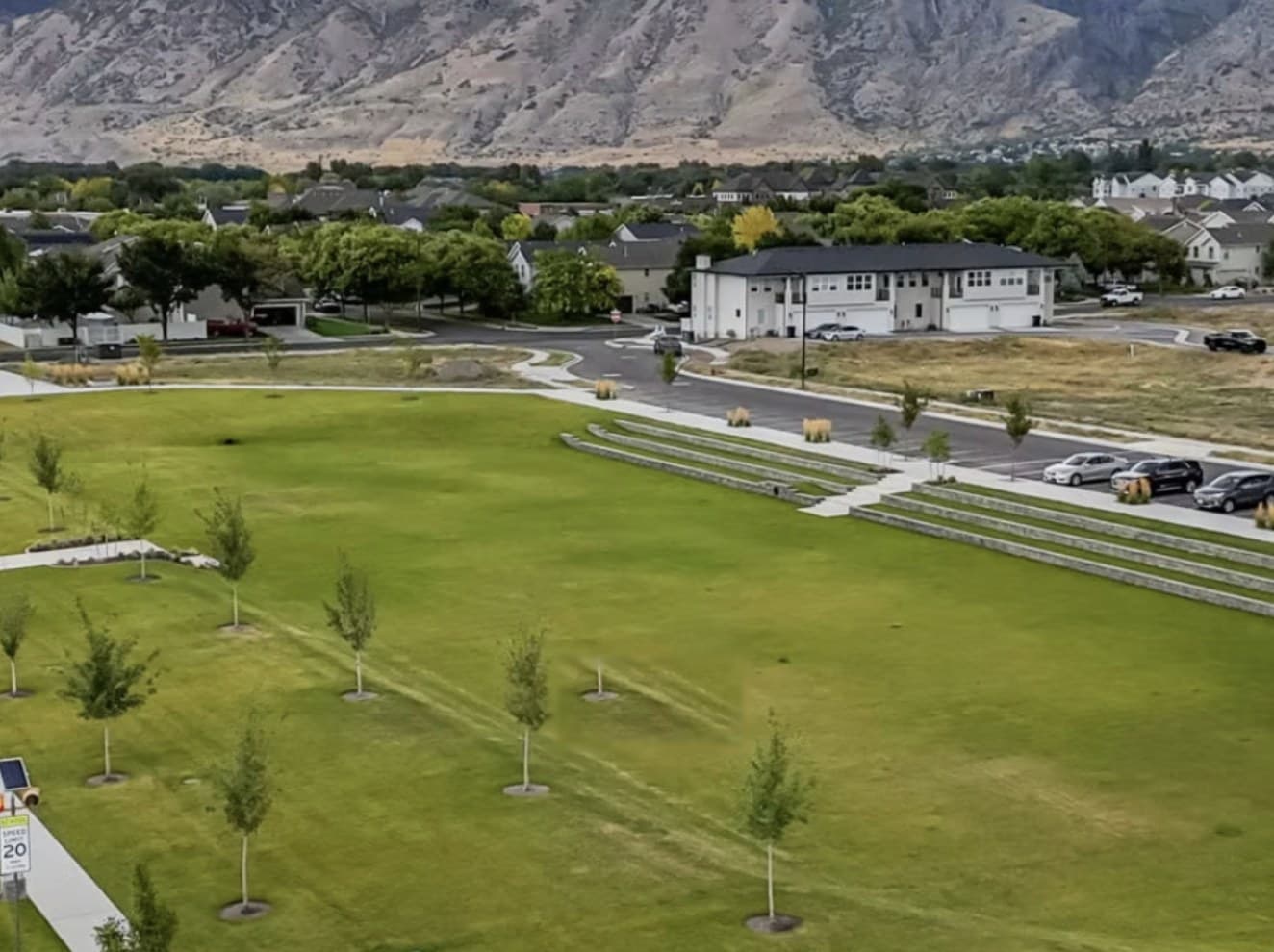 The open central green at Huntington Ranch, framed by the Wasatch mountains.